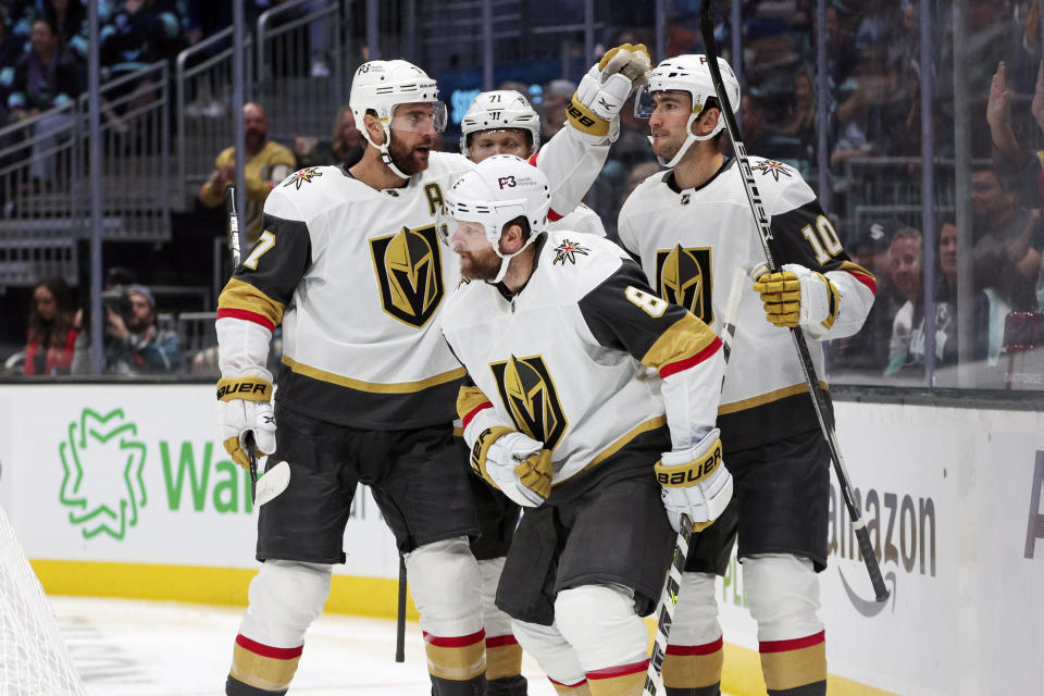 Vegas Golden Knights players, from left, Alex Pietrangelo, William Karlsson (71), Phil Kessel (8) and Nicolas Roy celebrate a goal by Jonathan Marchessault during the first period of an NHL hockey game against the Seattle Kraken, Saturday, Oct. 15, 2022, in Seattle. (AP Photo/Jason Redmond)