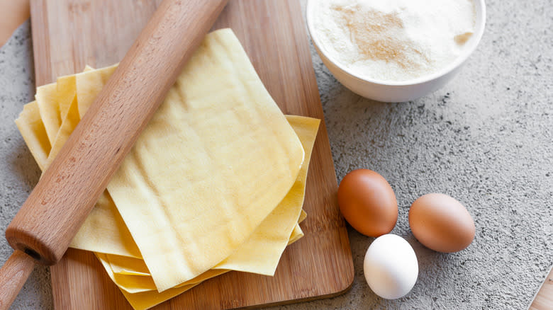 thin sheets of dough with a rolling pin, eggs, and flour