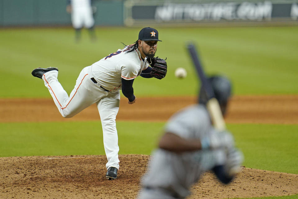 Houston Astros relief pitcher Roberto Osuna, left, throws to Seattle Mariners' Kyle Lewis during the ninth inning of a baseball game Monday, July 27, 2020, in Houston. The Astros won 8-5. (AP Photo/David J. Phillip)