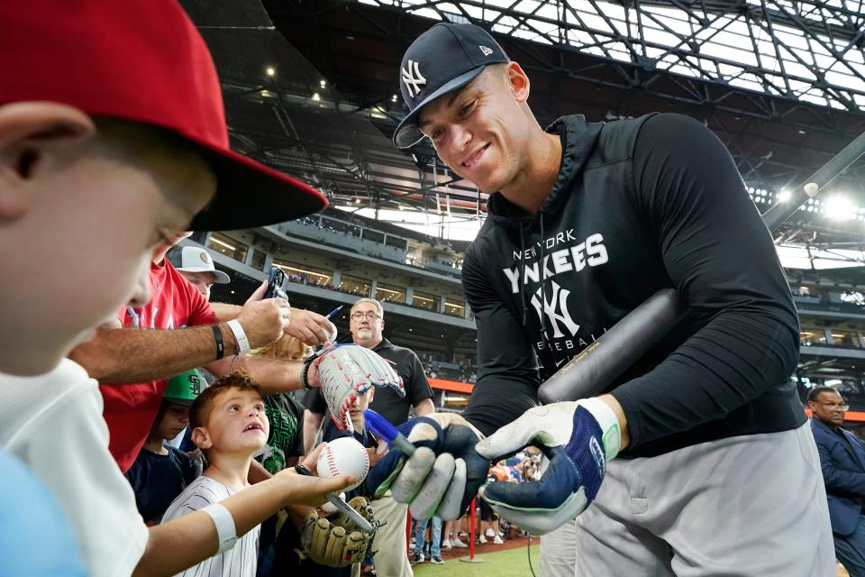 New York Yankees' Aaron Judge signs autographs during batting practice before a baseball game against the Texas Rangers in Arlington, Texas, Monday, Oct. 3, 2022. (AP Photo/LM Otero)