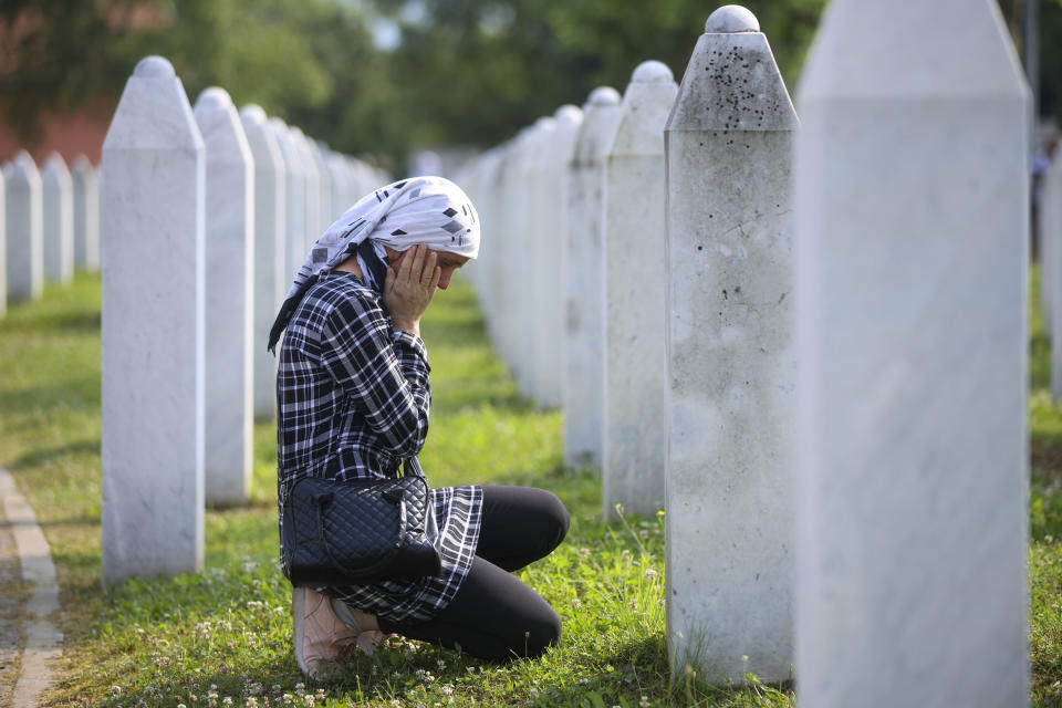 A Bosnian muslim woman mourns next to the grave of her relative, victim of the Srebrenica genocide, at the Memorial Centre in Potocari, Bosnia, Tuesday, July 11, 2023. Thousands gahter in the eastern Bosnian town of Srebrenica to commemorate the 28th anniversary on Monday of Europe's only acknowledged genocide since World War II. (AP Photo/Armin Durgut)