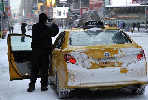 Un taxista fotografiando Times Square en la mañana del 3 de enero de 2014 en Nueva York, tras la primera gran tormenta de invierno sobre la ciudad (AFP | Timothy Clary)