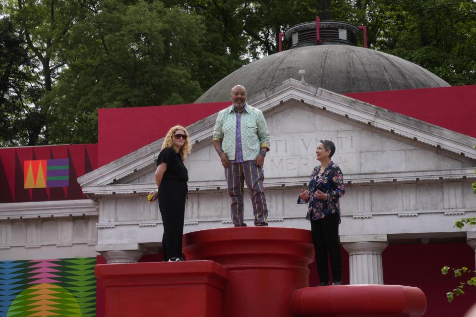 From left, Curator Abigail Winograd, artist Jeffrey Gibson, and Curator Kathleen Ash-Milby pose at the US pavilion during the media open day at the 60th Biennale of Arts in Venice, Italy, Tuesday, April 16, 2024. A Mississippi Choctaw of Cherokee descent, Gibson is the first Native American to represent the United States solo at the Venice Biennale, the world’s oldest contemporary art show. Gibson mixes Western modernism and Native American craft in his vibrantly hued paintings and sculptures. (AP Photo/Luca Bruno)