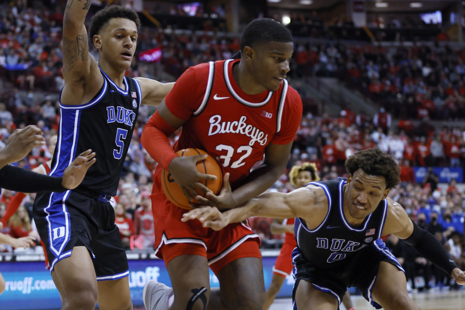 Ohio State's E.J. Liddell, center, grabs a loose ball from Duke's Paolo Banchero, left, and Wendell Moore during the second half of an NCAA college basketball game Tuesday, Nov. 30, 2021, in Columbus, Ohio. (AP Photo/Jay LaPrete)