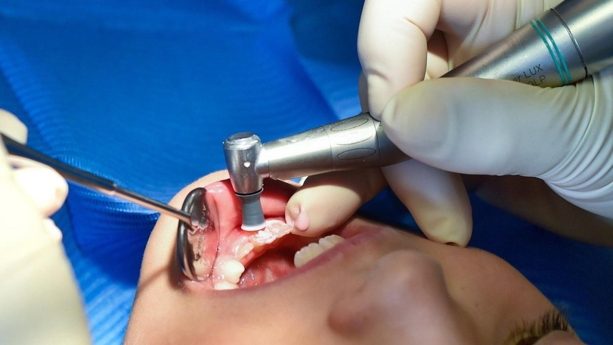 Ein siebenjähriges Mädchen wird von einer Zahnärztin behandelt.