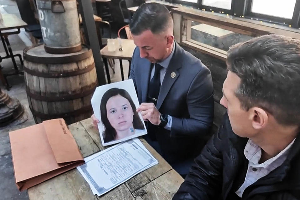 NYPD Detective Ryan Glas holds a digital composite photo of Patricia Kathleen McGlone. (WNBC)
