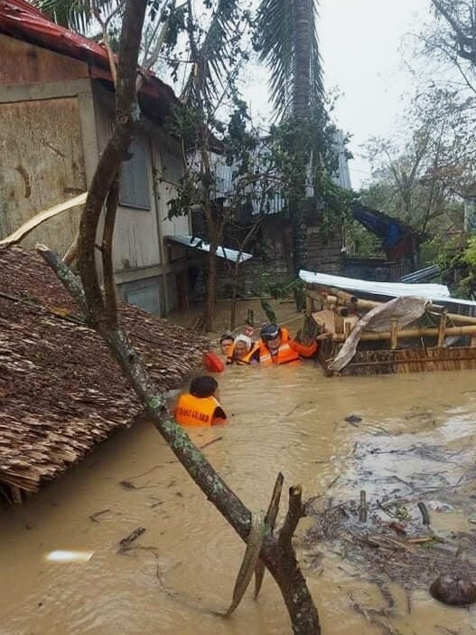 CORRECTS THE AREA TO NEGROS OCCIDENTAL, INSTEAD OF LOBOC, BOHOL - In this photo provided by the Philippine Coast Guard, rescuers assist residents who were trapped in their homes after floodwaters caused by Typhoon Rai inundated their village in Negros Occidental, central Philippines on Friday, Dec. 17, 2021. The strong typhoon engulfed villages in floods that trapped residents on roofs, toppled trees and knocked out power in southern and central island provinces, where more than 300,000 villagers had fled to safety before the onslaught, officials said. (Philippine Coast Guard via AP)