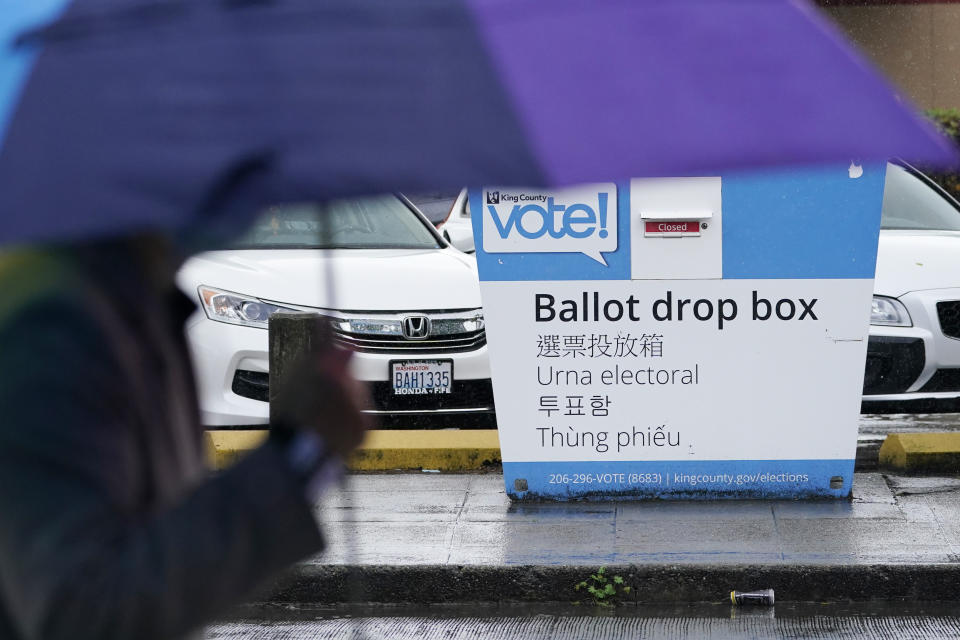 A pedestrian walks past a King County ballot drop box, closed until ballots are mailed about three weeks before the election, on a Seattle street Thursday, Sept. 24, 2020. (AP Photo/Elaine Thompson)