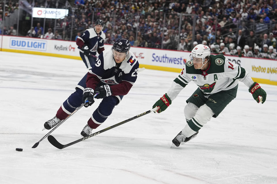 Colorado Avalanche center Nathan MacKinnon (29) drives to the net against Minnesota Wild center Joel Eriksson Ek (14) in the second period of an NHL hockey game Tuesday, April 9, 2024, in Denver. (AP Photo/Bart Young)