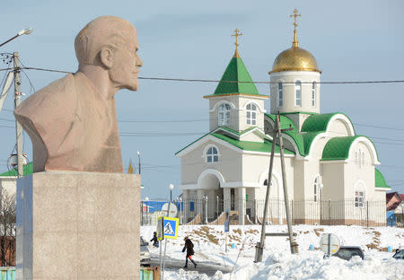 FILE PHOTO: A bust of Soviet state founder Vladimir Lenin is seen in front of a Russian Orthodox church in Yuzhno-Kurilsk, on the Island of Kunashir, one of four islands known as the Southern Kurils in Russia and the Northern Territories in Japan, December 21, 2016. REUTERS/Yuri Maltsev/File Photo