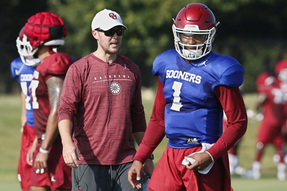 FILE - In this Monday, Aug. 5, 2019 file photo, Oklahoma head coach Lincoln Riley watches quarterback Jalen Hurts (1) during an NCAA college football practice in Norman, Okla. Oklahoma quarterback Jalen Hurts is cramming as he prepares for his only year with the Sooners. Before transferring from Alabama, he played in three national title games. (AP Photo/Sue Ogrocki, File)