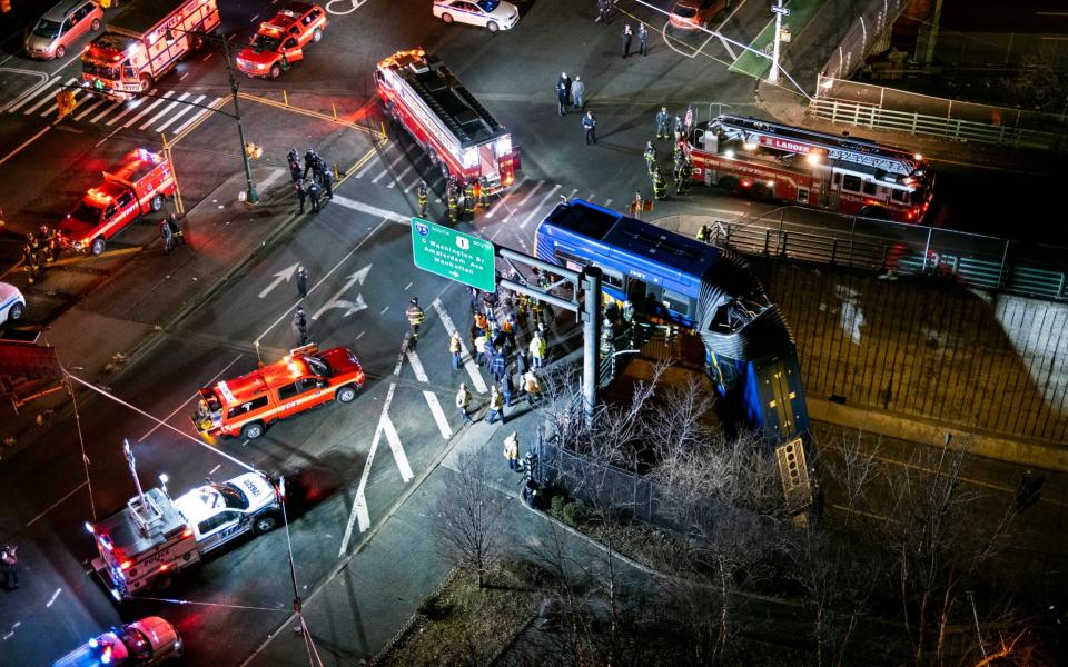A bus in New York City which careened off a road in the Bronx neighborhood of New York is left dangling from an overpass - Craig Ruttle /FR61802 AP 