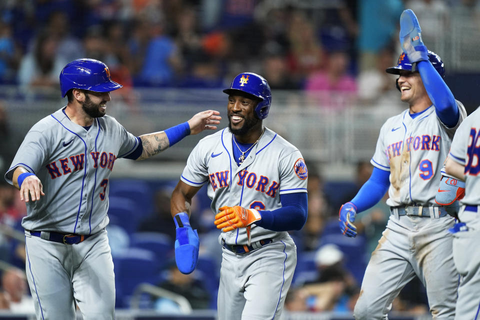 New York Mets' Tomas Nido, left, Starling Marte, center, and Brandon Nimmo celebrate after scoring on a double by Francisco Lindor during the sixth inning of the team's baseball game against the Miami Marlins, Friday, June 24, 2022, in Miami. (AP Photo/Lynne Sladky)