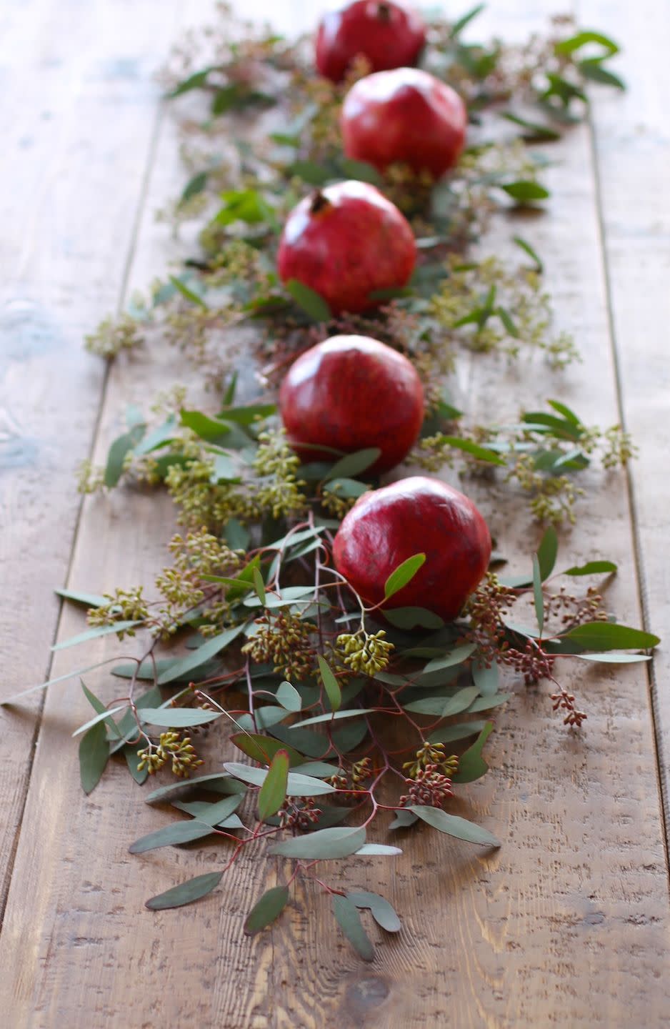 <p>Bright red pomegranates make a festive addition to a table runner.</p><p>See more at <a href="http://julieblanner.com/5-minute-floral-christmas-table-runner/" rel="nofollow noopener" target="_blank" data-ylk="slk:Julie Blanner;elm:context_link;itc:0;sec:content-canvas" class="link ">Julie Blanner</a>. </p>