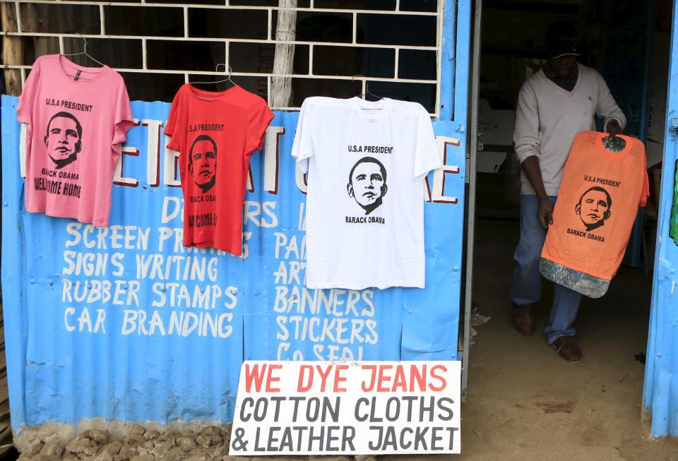 Wycliff Madegwa prepares to display a t-shirt newly printed with the image of U.S. President Barack Obama, ahead of his scheduled state visit, in Kenya's capital Nairobi July 23, 2015. Obama will land in Kenya on Friday with a mission to strengthen U.S. security and economic ties, but his personal connection to his father's birthplace will dominate a trip that Kenyans view as a native son returning home. (REUTERS/Noor Khamis)