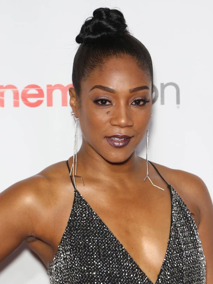 Tiffany Haddish at an event wearing a sparkly sleeveless dress with long earrings