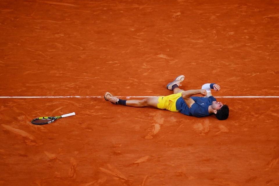 Carlos Alcaraz falls to the clay after winning the French Open for the first time  (Getty)