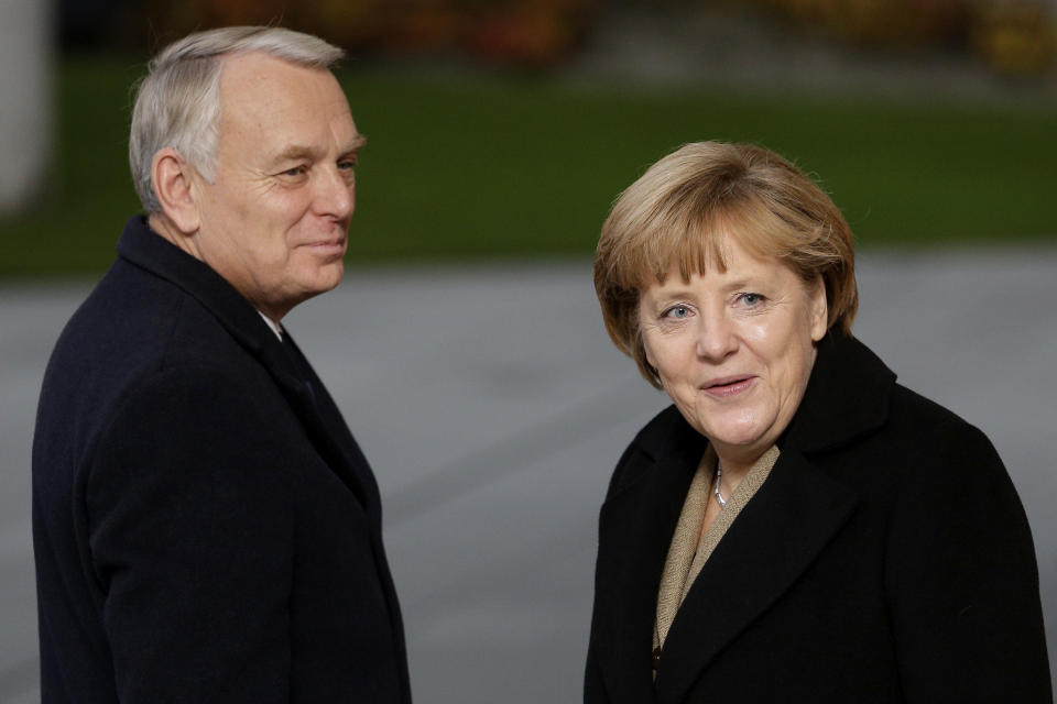 German Chancellor Angela Merkel, right, reacts as she welcomes the Prime Minister of France, Jean-Marc Ayrault, left, in front of the chancellery in Berlin, Germany, Thursday, Nov. 15, 2012. (AP Photo/Michael Sohn)