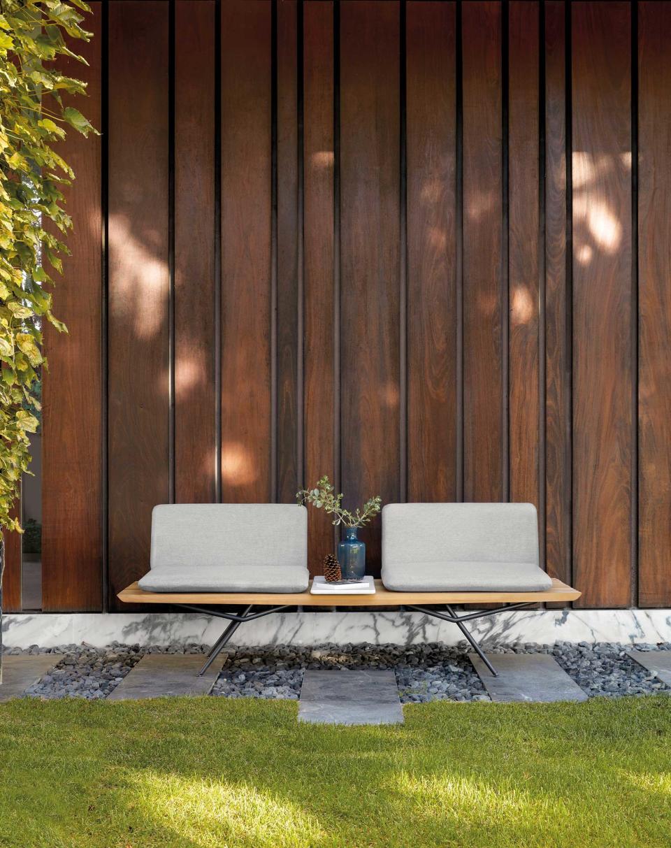 <p> If you&apos;re looking for a small patio (or in this case, <em>very</em> small patio ideas), then gravel may well be the way forward. This tiny seating space, for instance, is given all the definition it needs with a modern duo of grey stones and paving beneath a streamlined bench. </p> <p> Positioned alongside a lawn it provides a chic seating set-up which will keep footfall safely off the turf &#x2013; especially important if it&apos;s raining. </p>