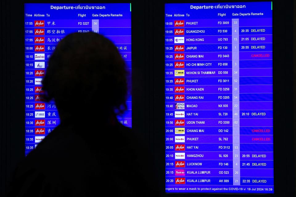 A passenger looks at a flight schedule screen inside Don Mueang International Airport Terminal 1 amid system outages disrupting the airline's operations, in Bangkok, Thailand, July 19, 2024.