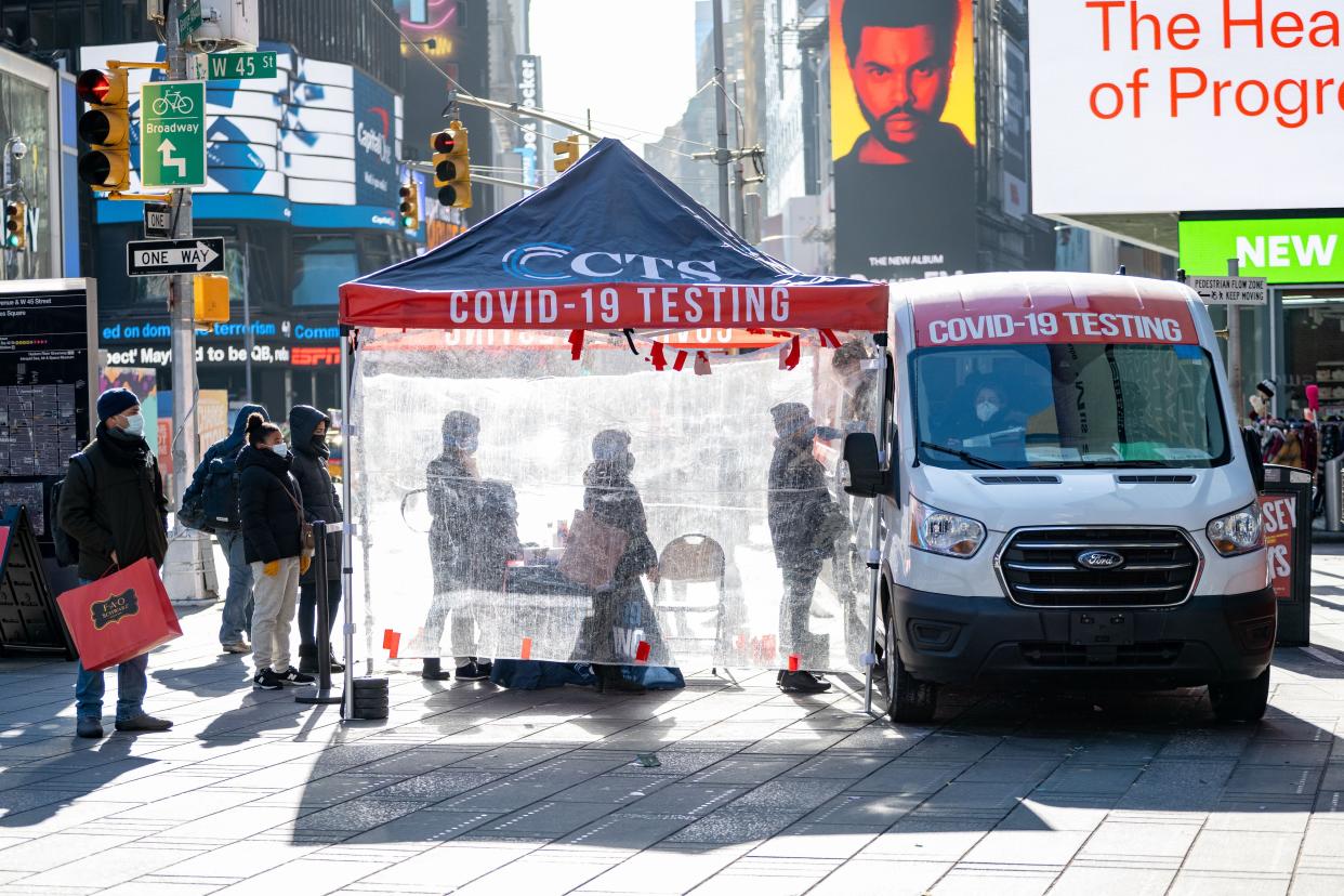 People stand in line at Times Square to get COVID-19 tests in Manhattan, New York.