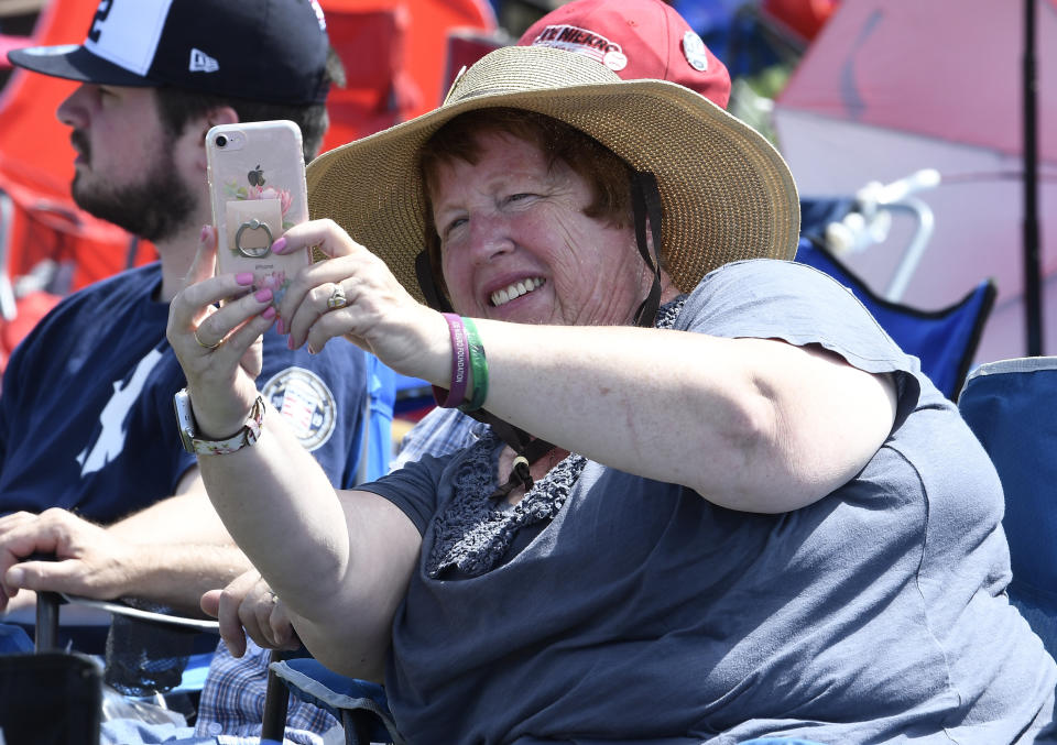 Judy Riker of Bridgewater, N.Y., takes a selfie photograph while waiting for the start of the National Baseball Hall Of Fame induction ceremony at the Clark Sports Center on Sunday, July 21, 2019, in Cooperstown, N.Y. (AP Photo/Hans Pennink)