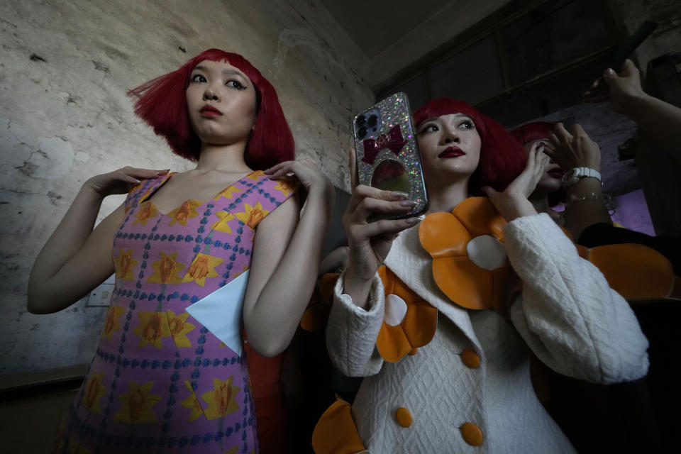 Dos modelos se preparan para el espectáculo Dieyingchongchong del diseñador Dong Yaer para la Semana de la Moda de China, el 7 de septiembre de 2022, en Beijing. (AP Foto/Ng Han Guan)