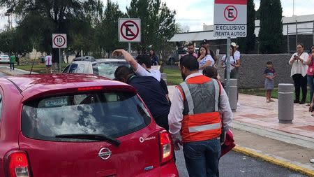 A man is helped into a car outside the Durango Airport after an Aeromexico-operated Embraer passenger jet crashed right after takeoff in Mexico's state of Durango, July 31, 2018, in this picture obtained from social media. Contacto Hoy/via REUTERS