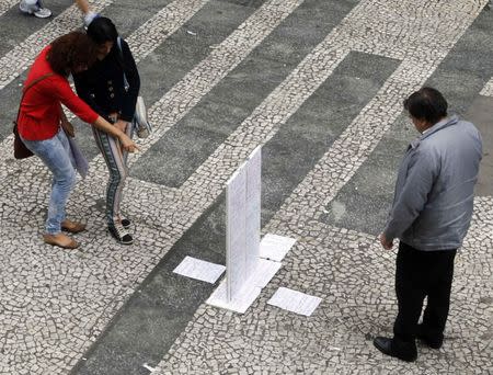 People look at a list of jobs offered in a main street in downtown Sao Paulo August 13, 2014. REUTERS/Paulo Whitaker