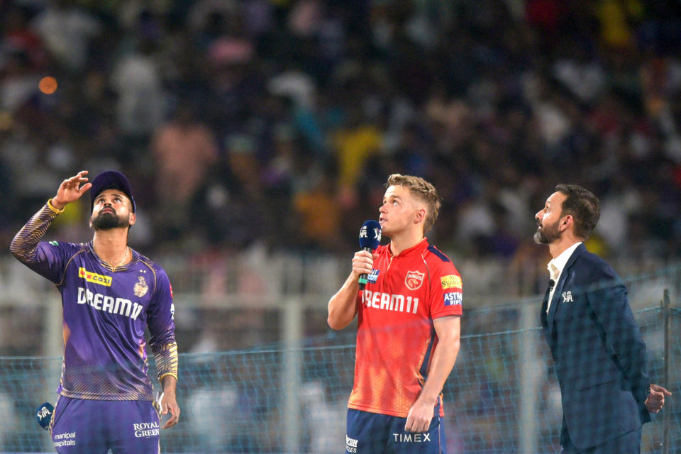 Kolkata Knight Riders' captain Shreyas Iyer (L) tosses the coin as his Punjab Kings' counterpart Sam Curran (C) looks on at the start of the Indian Premier League (IPL) Twenty20 cricket match between Kolkata Knight Riders and Punjab Kings at the Eden Gardens in Kolkata on April 26, 2024. (Photo by AFP) / -- IMAGE RESTRICTED TO EDITORIAL USE - STRICTLY NO COMMERCIAL USE -- (Photo by -/AFP via Getty Images)