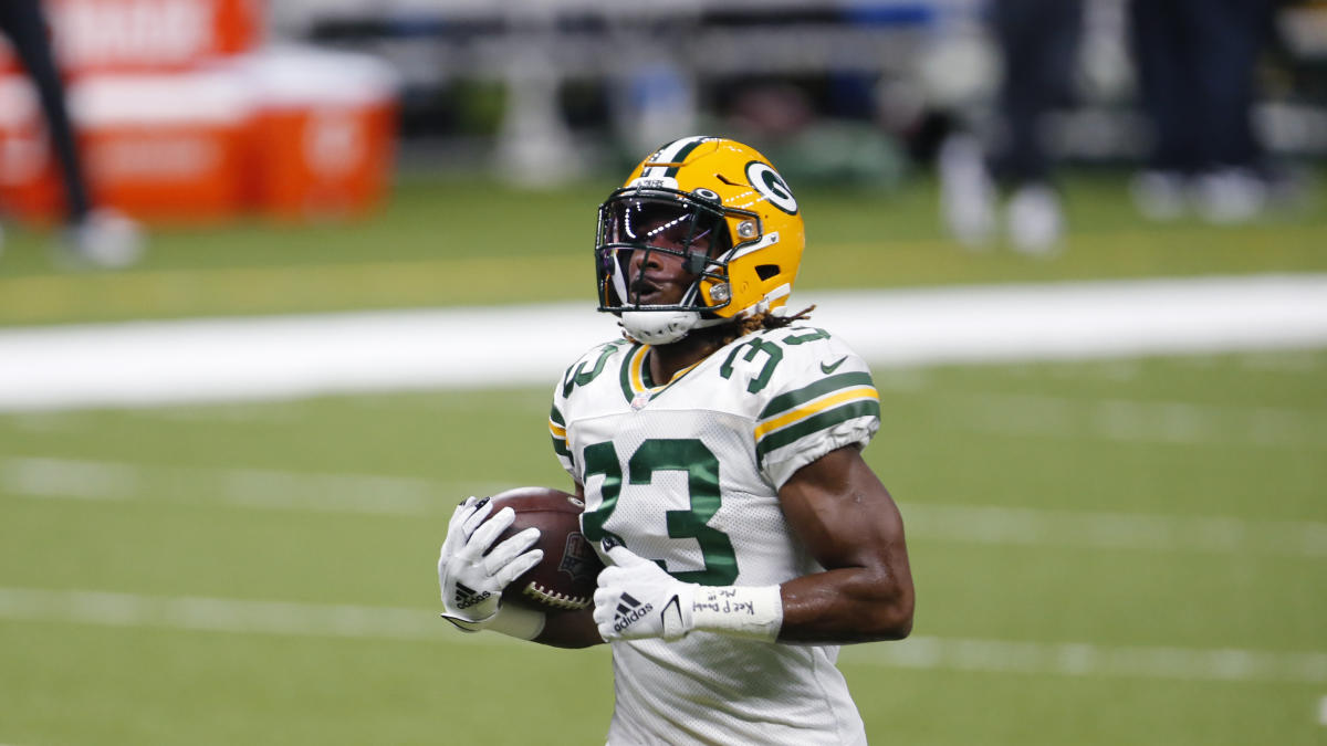 Green Bay Packers running back Aaron Jones (33) runs in front of San  Francisco 49ers cornerback Richard Sherman (25) and strong safety Jaquiski  Tartt (29) during the NFL football NFC Championship game