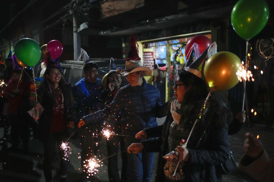 Residents with light flares participate in the procession of "Ninopan" during a Christmas "posada," which means lodging or shelter, in the Xochimilco borough of Mexico City, Wednesday, Dec. 21, 2022. For the past 400 years, residents have held posadas between Dec. 16 and 24, when they take statues of baby Jesus in procession to church for Mass to commemorate Mary and Joseph's cold and difficult journey from Nazareth to Bethlehem in search of shelter. (AP Photo/Eduardo Verdugo)