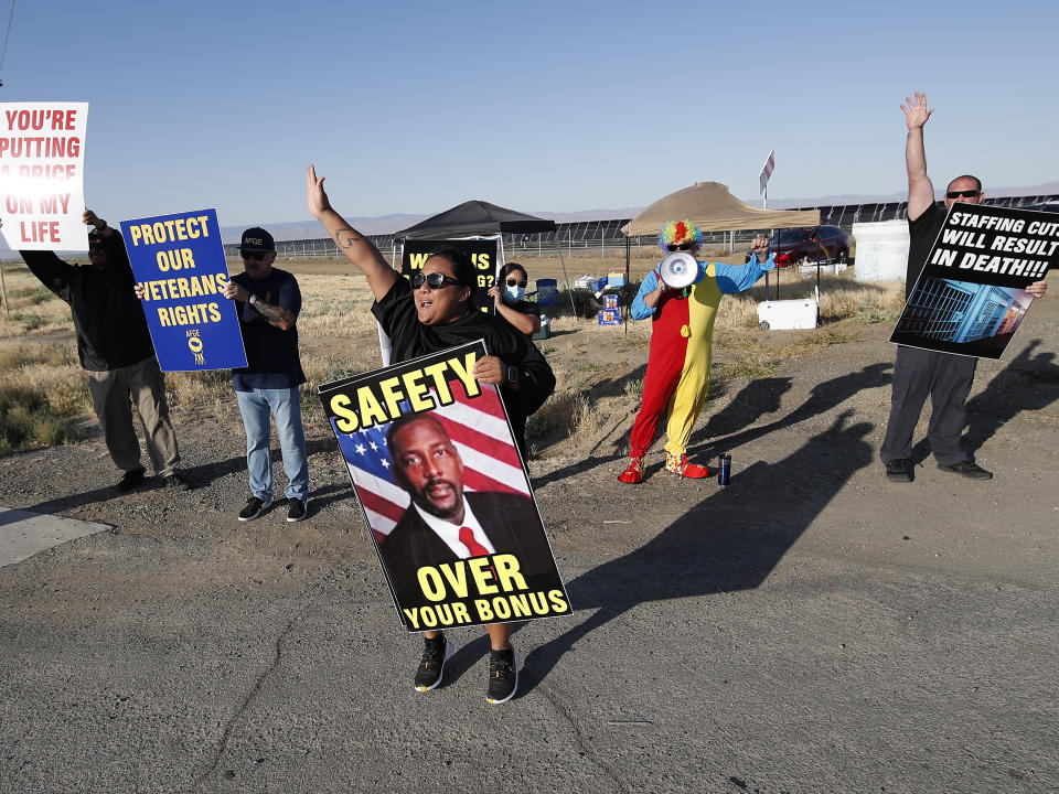 Noni Ahulau, from Honolulu, holding a sign of Warden Douglas K. White, protests staffing shortages at the Federal Correctional Institution at Mendota, Monday, May 17, 2021, near the facility, in Mendota, Calif. (AP Photo/Gary Kazanjian)