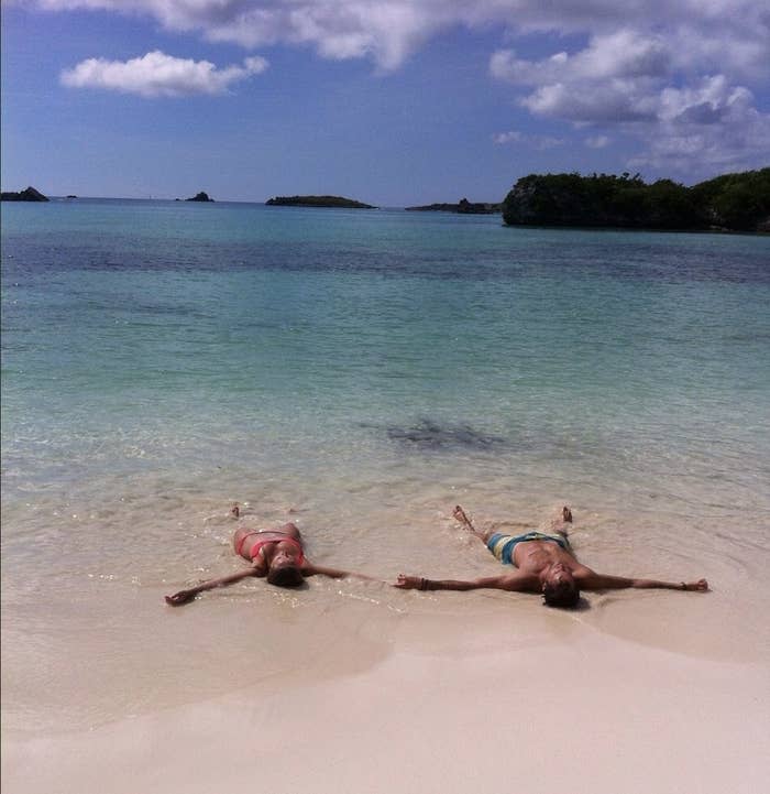 Couples lays on sand in the ocean