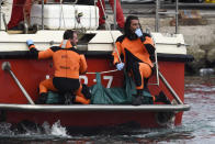 Italian Firefighters scuba divers return to the harbor with a body bag, Wednesday, Aug. 21, 2024, in the Sicilian village of Porticello near Palermo, in southern Italy. (AP Photo/Salvatore Cavalli