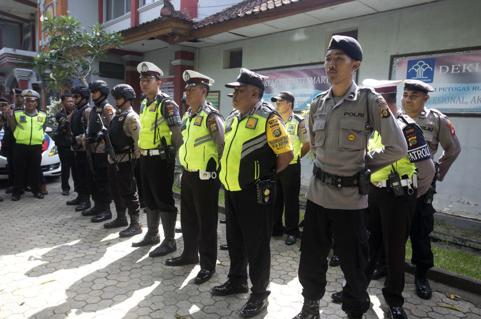 Police officers line up in front of Bangli prison as they provide security before the release of Australian woman Renae Lawrence in Bali, Indonesia, Wednesday, Nov. 21, 2018. Lawrence freed Wednesday after serving nearly 14 years in prison for smuggling heroin to the tourist island of Bali will be deported and banned from the country for life. (AP Photo/Firdia Lisnawati)