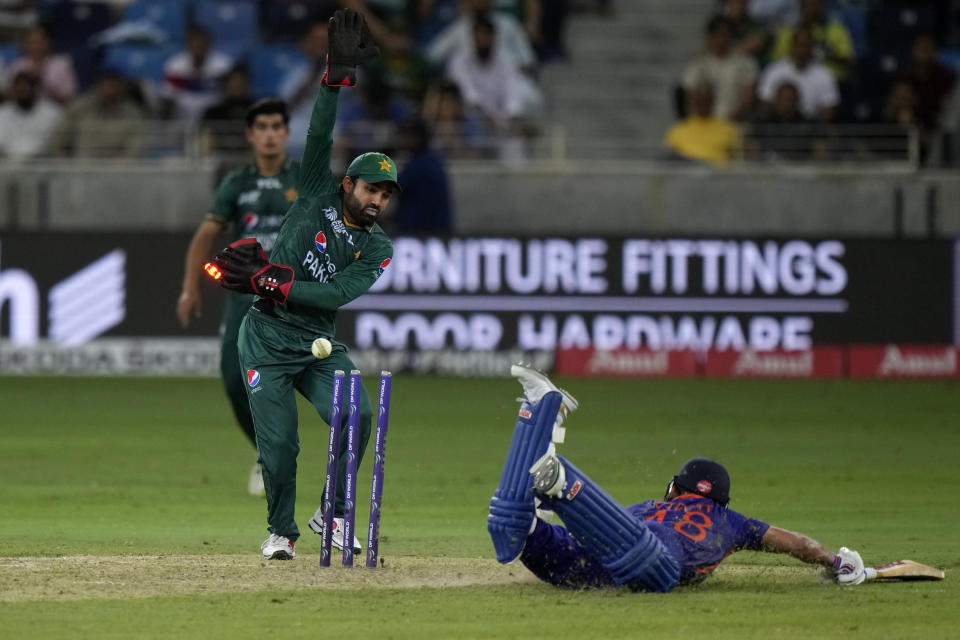 Pakistan's wicketkeeper Mohammad Rizwan, left, breaks the stumps to run-out India's Virat Kohli, on ground, during the T20 cricket match of Asia Cup between India and Pakistan, in Dubai, United Arab Emirates, Sunday, Sept. 4, 2022. (AP Photo/Anjum Naveed)