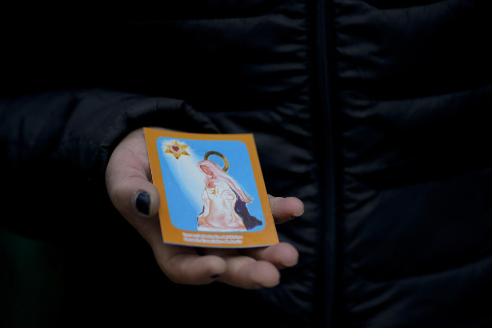 A street seller shows a stamp of the popular “Madonna del Cerro,” or Immaculate Mother of the Divine Eucharistic Heart of Jesus, in Salta, Argentina, Monday, May 2, 2022. The archbishop of Salta province, Mario Antonio Cargnello, has long had a dispute with the nuns over the “Madonna del Cerro,” a popular figure in Salta who a woman in the province said appeared to her in a vision in the 1990s. Cargnello does not recognize the figure, but Carmelite nuns do. (AP Photo/Natacha Pisarenko)