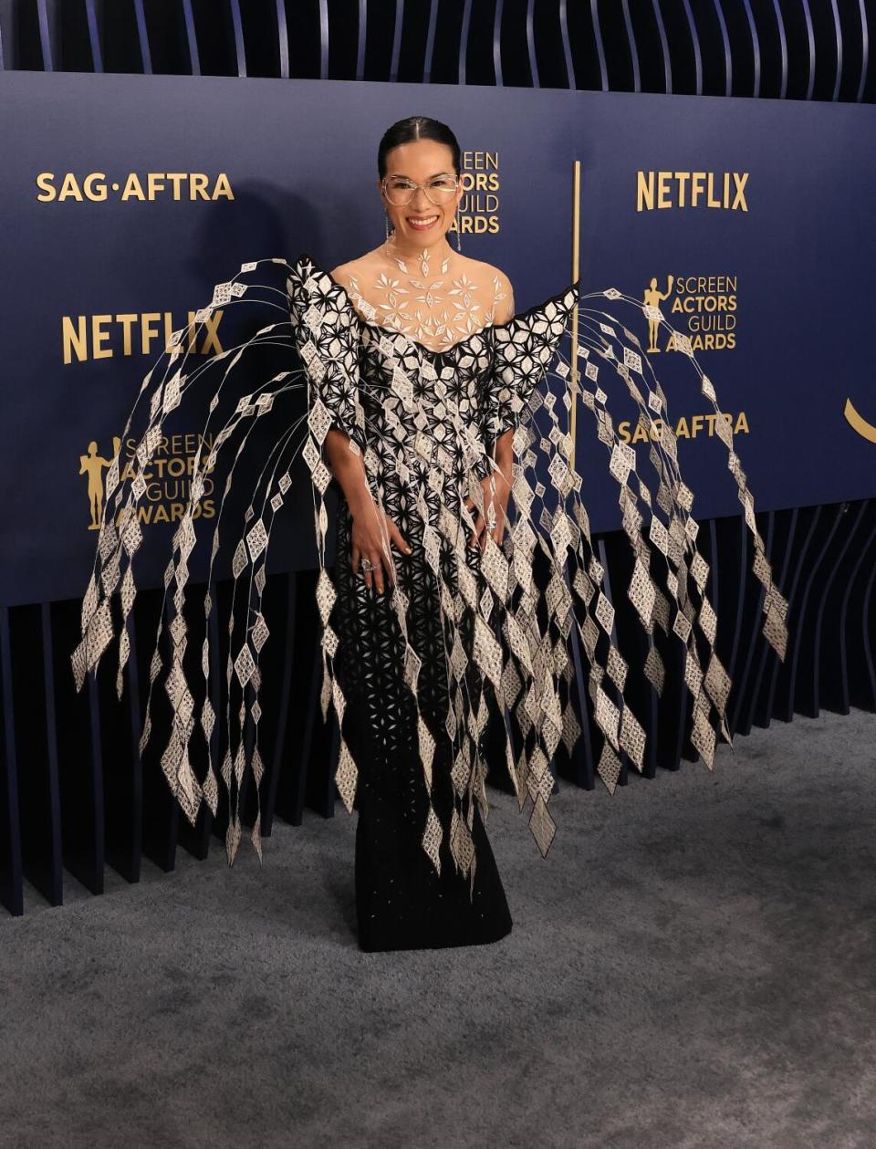 Ali Wong wears a black and white dress with a fountain of feathers at the SAG Awards.