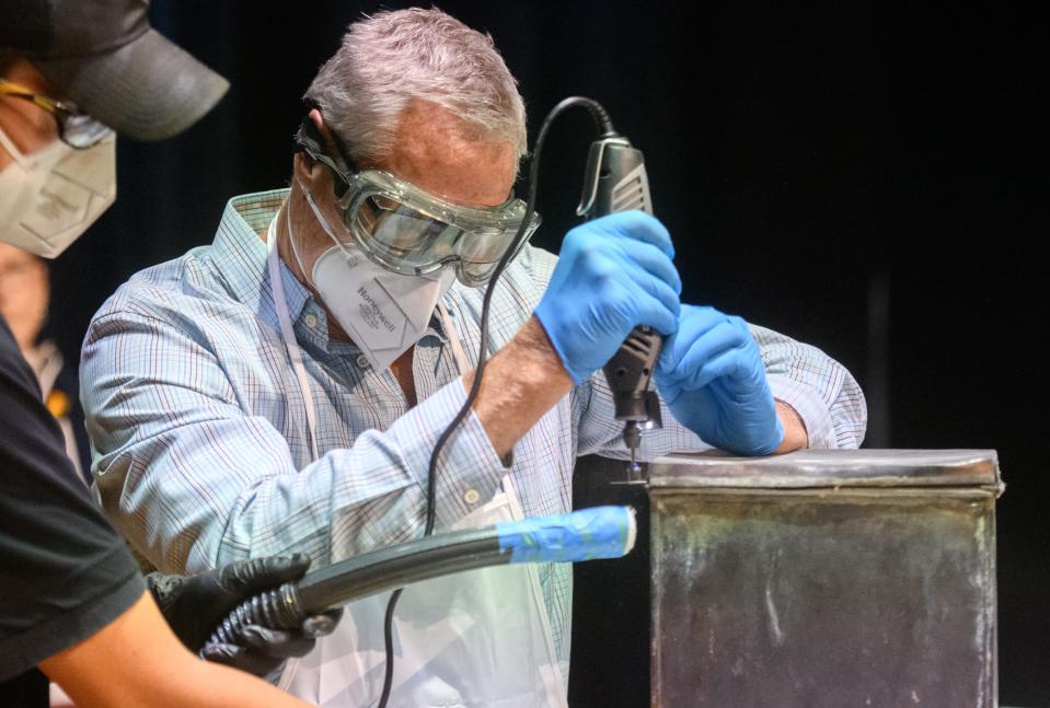 Decked out in goggles, gloves and a protective mask, Greg Birkland of the KDB Group cuts through the lid of the Hale Memorial Church time capsule Tuesday, Sept. 20, 2022 at the Scottish Rite Cathedral in Peoria.