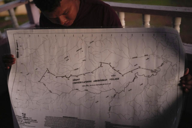 Orin Fernandes, a toshao, or Indigenous leader, holds a map of Chinese Landing's Amerindian territory, in Chinese Landing, Guyana, Monday, April 17, 2023. Chinese Landing secured its land title in 1976. (AP Photo/Matias Delacroix)