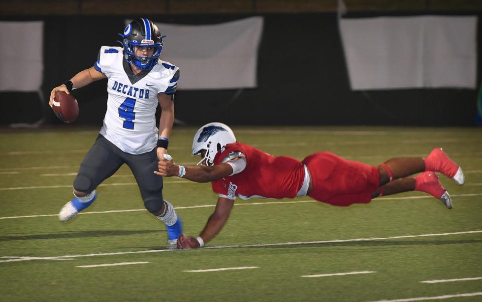 Hirschi Huskie lineman Javian Frazier (5) attempts to stop Decatur quarterback Preston Escobar (4) during Friday night's game at Memorial Stadium. The Huskies defeated the Eagles, 28-22.