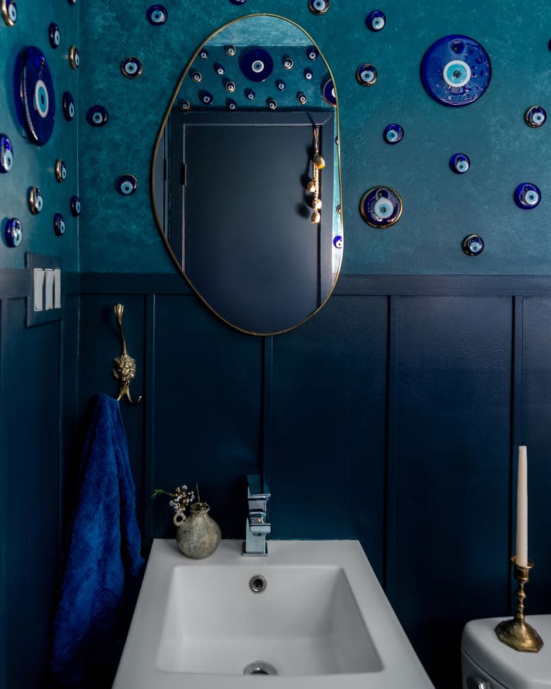 Decorative plates on wall in blue hued bathroom.