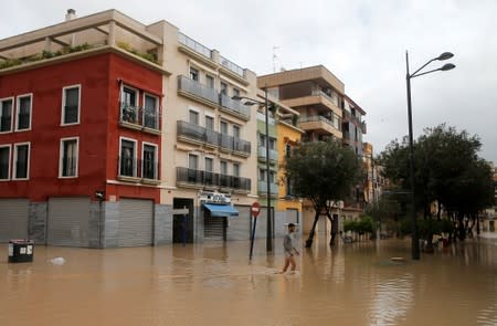 A man walks through a flooded street as torrential rains hit Orihuela