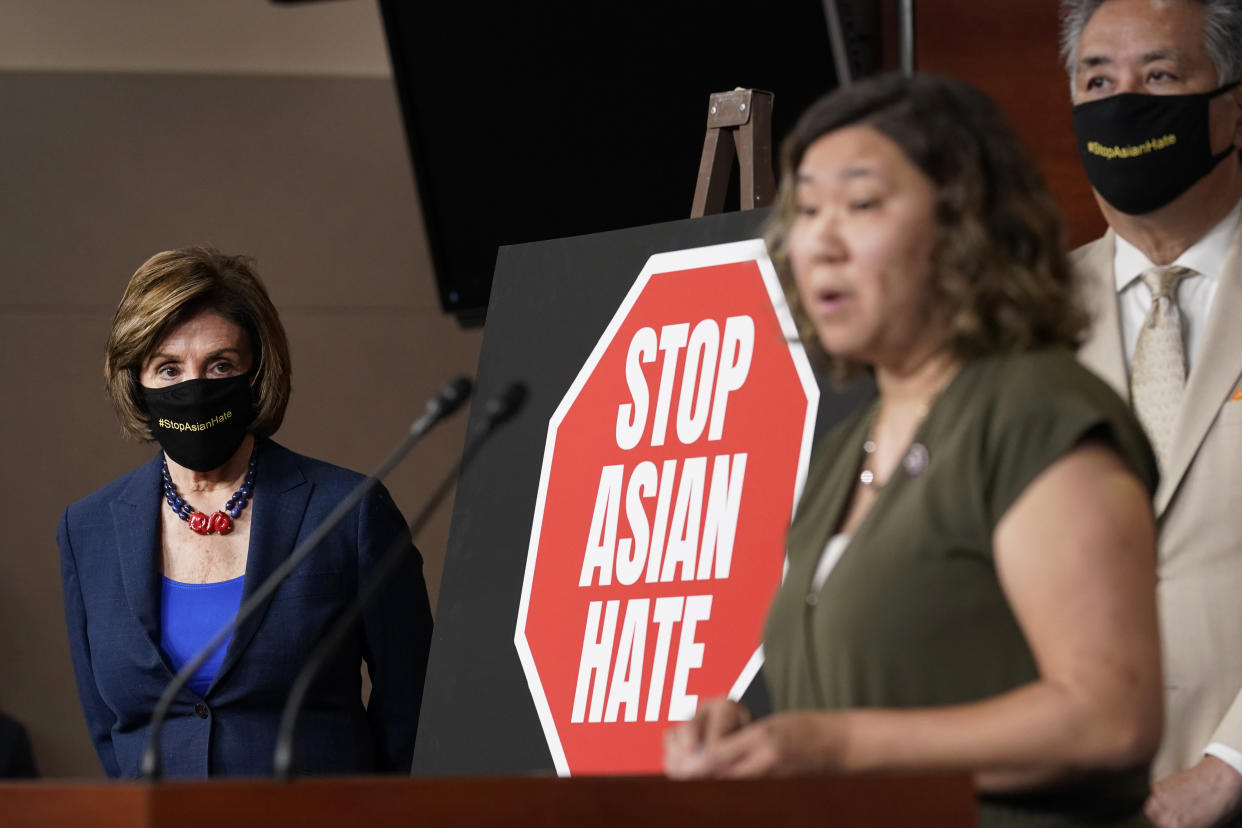 House Speaker Nancy Pelosi of Calif., left, listens as Rep. Grace Meng, D-N.Y., center, speaks during a news conference on Capitol Hill in Washington, Tuesday, May 18, 2021, on the COVID-19 Hate Crimes Act. Rep. Mark Takano, D-Calif., listens at right. (AP Photo/Susan Walsh)