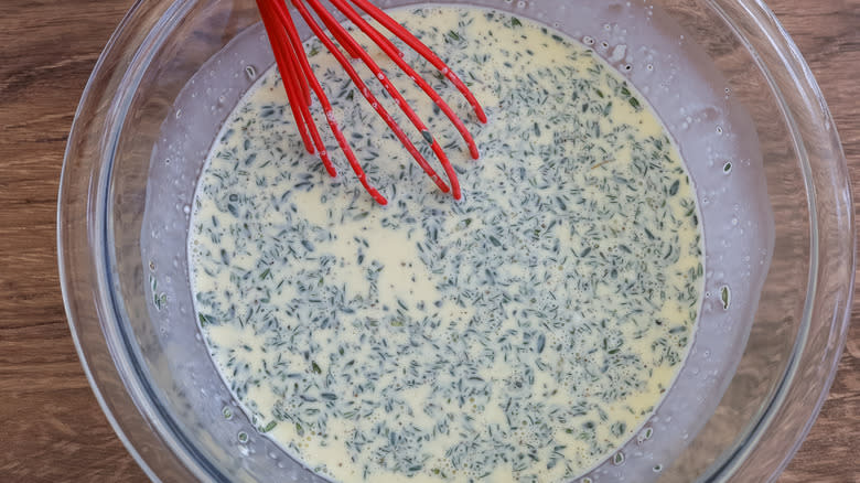 quiche filling in a bowl with a whisk