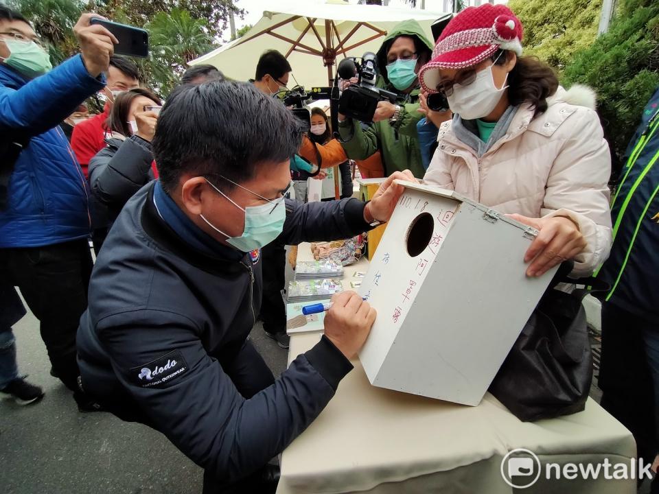 林佳龍在桐林社區的貓頭鷹信箱上簽名。    唐復年/攝