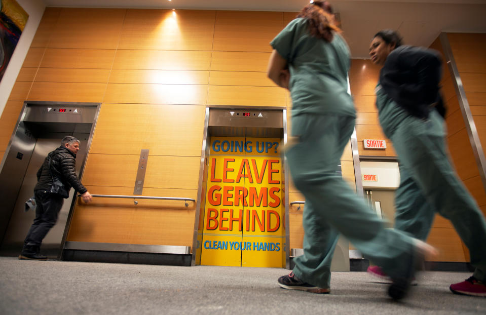 Staff and visitors walk past a sign indicating to wash hands on the elevator doors at the Jewish General Hospital in Montreal, Quebec, Canada March 2, 2020.  REUTERS/Christinne Muschi