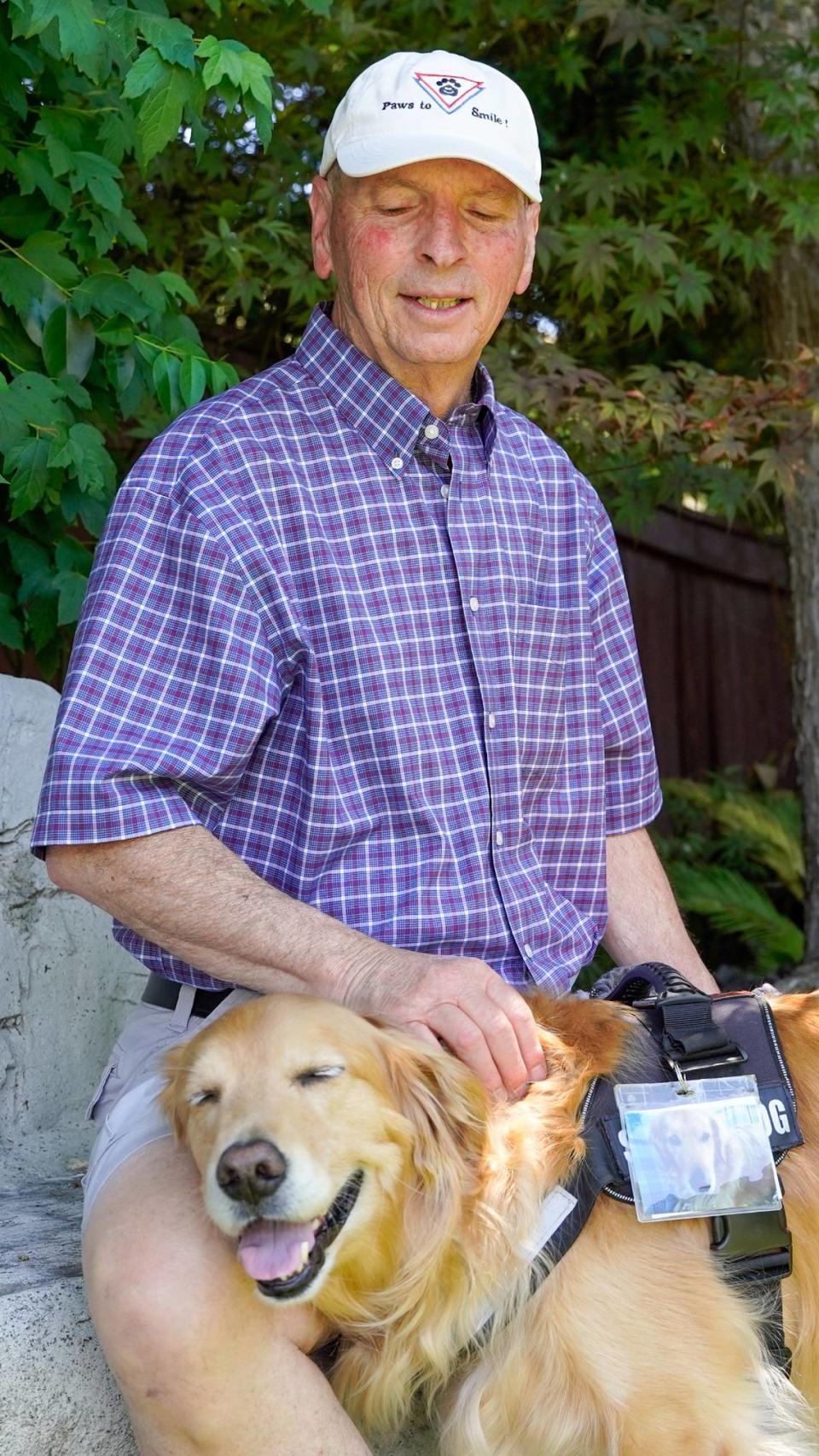 Dan Sievert, founder of Golden Missions of America, pets his service dog, Cooper. Sievert and his golden retrievers have made 55 missions across the United States over the past decade, helping victims of tragedies work through their trauma. John Lynch/jlynch@thetribunenews.com