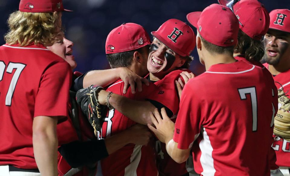 Hiland closer Isaak Yoder, facing, is mobbed by teammates after striking out the final Calvert batter in the eighth inning an OHSAA Division IV state semifinal baseball game at Canal Park, Thursday, June 8, 2023, in Akron, Ohio.